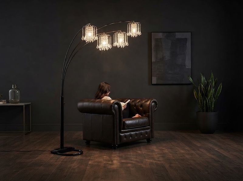 Dimmed crystal arc lamp over a dark dining table at night, faceted drops catch