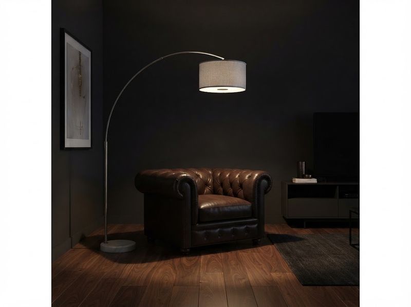 Hand screwing a warm-white LED bulb into an upturned fabric drum shade on a li