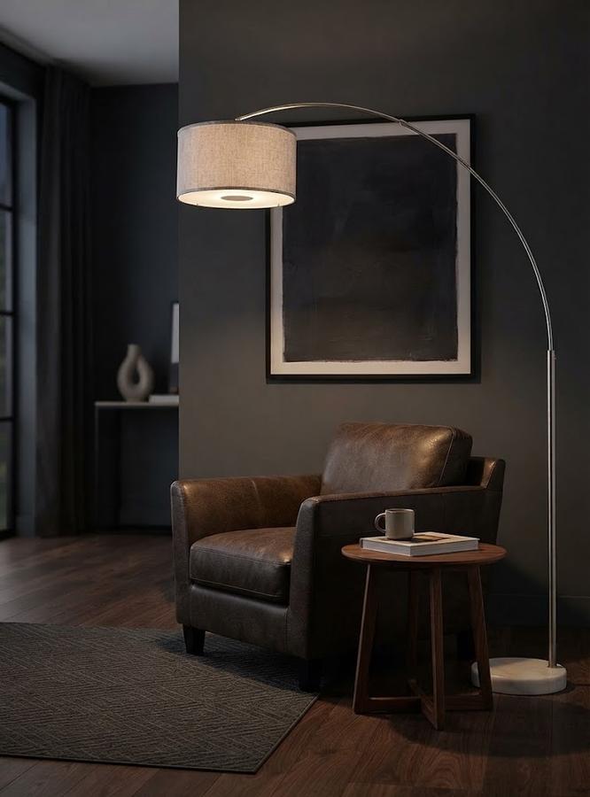 Grey drum shade lit above a living room sofa